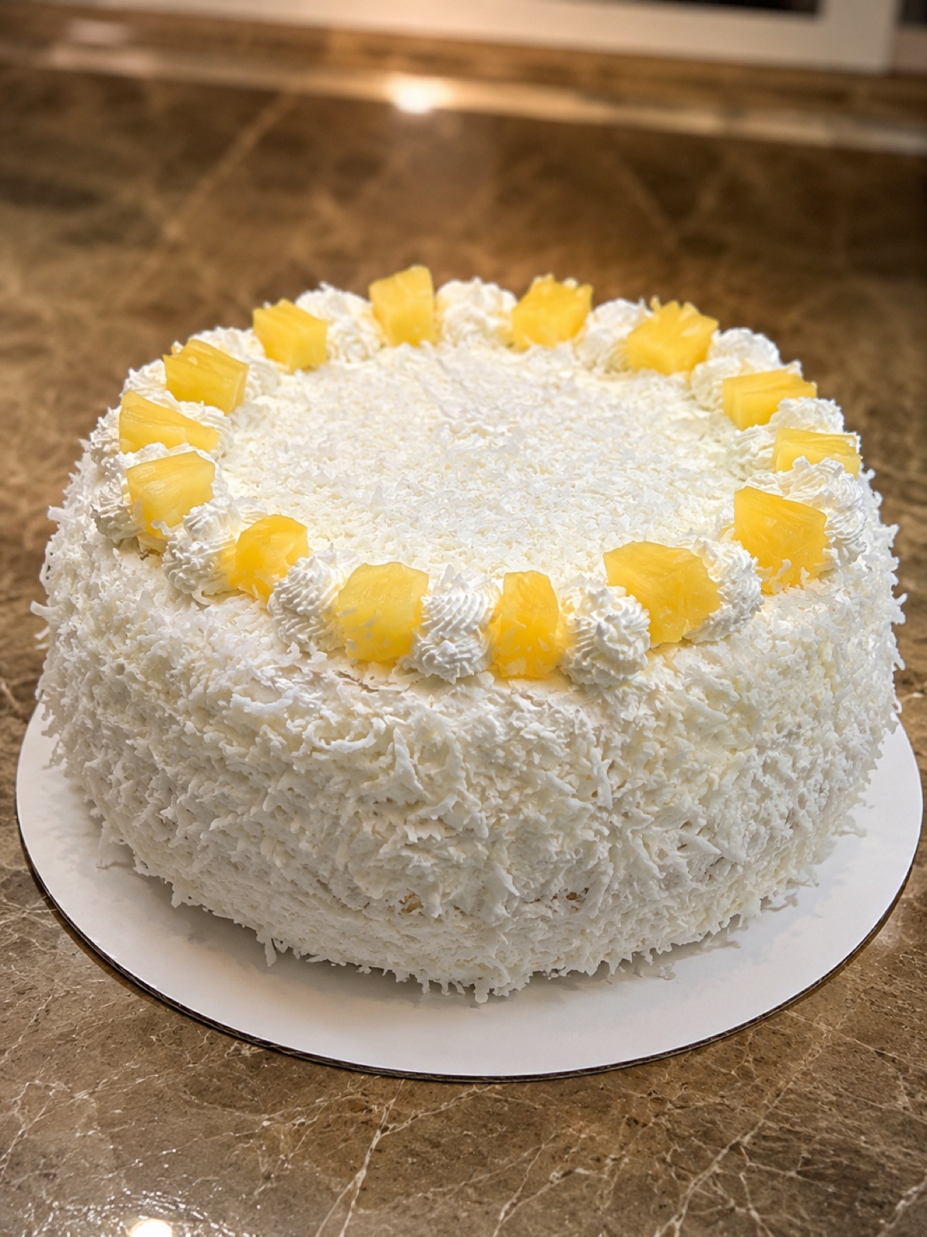Torta biscocho de crema y piña cubierta de coco rallado