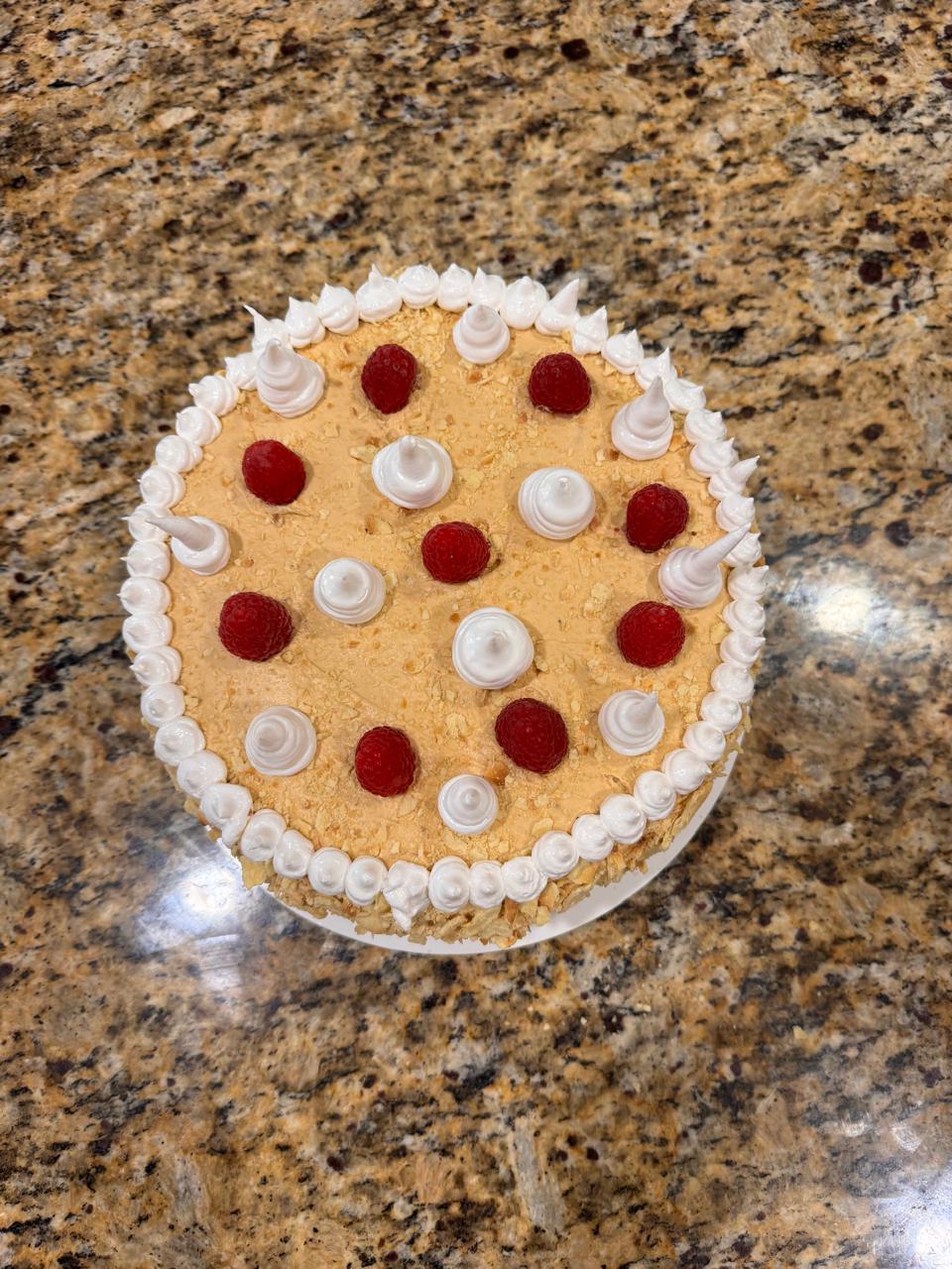 Vista superior de la Torta Amor decorada con merengues y frambuesas